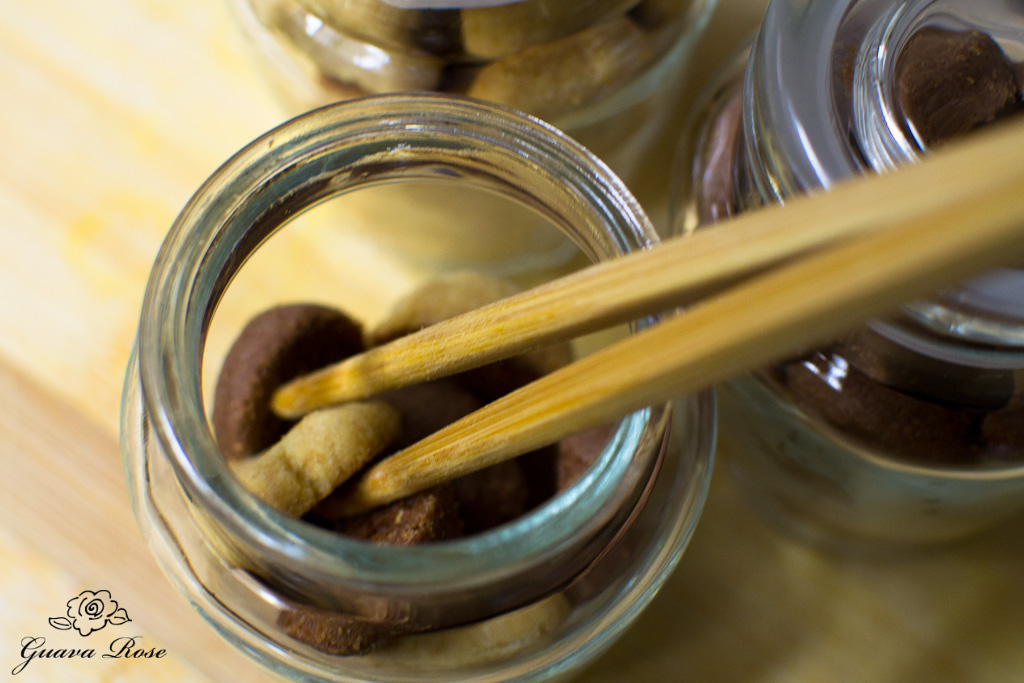 Using chopsticks to arrange malt cookies in glass jar