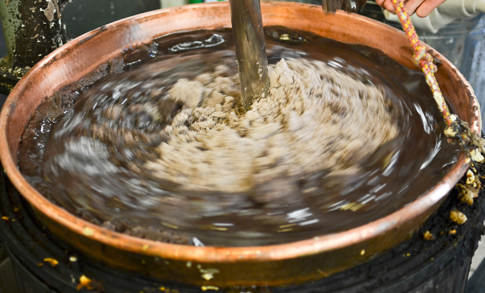 Stirring smooth bean filling with sugar in cooper kettle