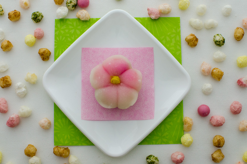 Single sakura shaped mochi surrounded by rice crackers