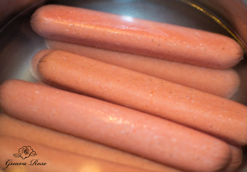 Hot dogs in water in pot