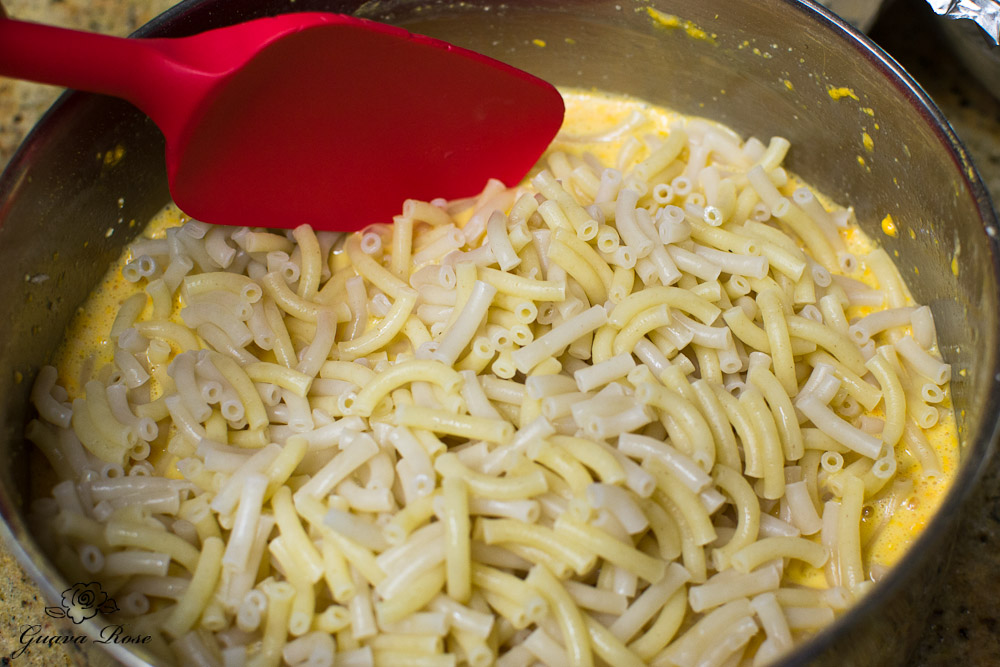 Adding cooked macaroni to cheese mixture