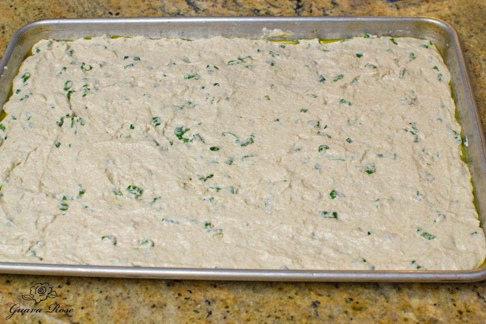 Buttermilk scallion flatbread dough spread out on baking sheet