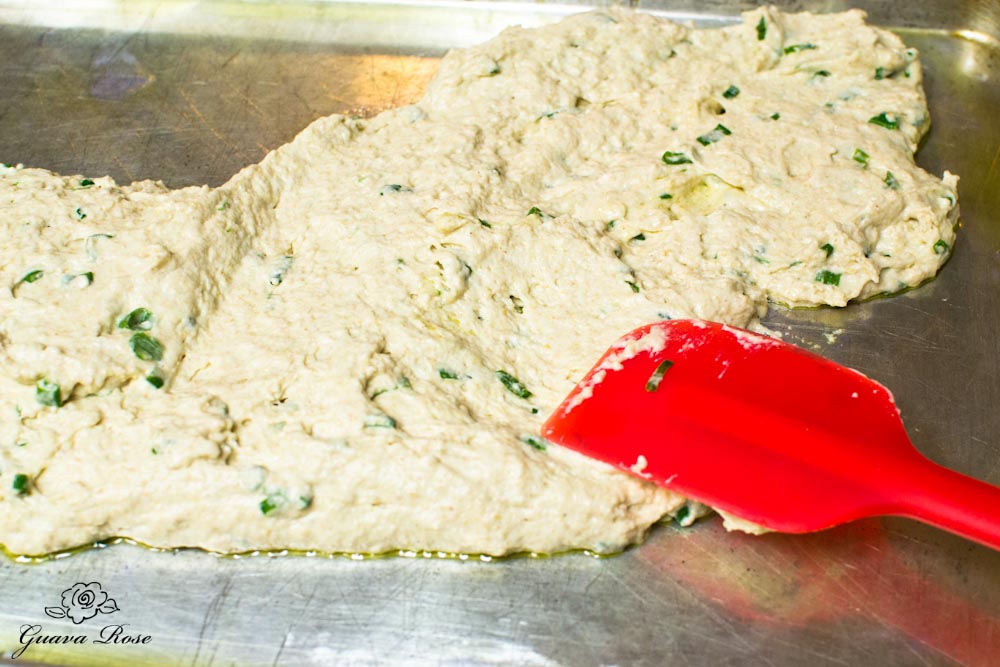 Spreading buttermilk scallion flatbread dough on baking sheet