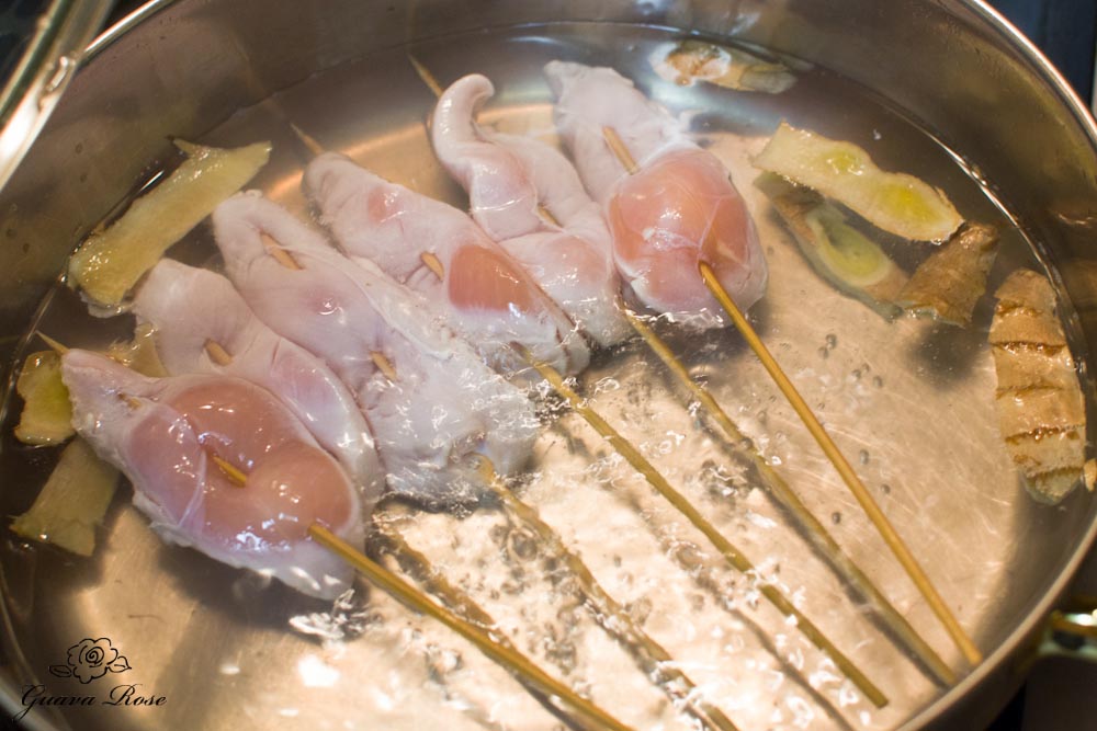 Chicken skewers placed in boiling water