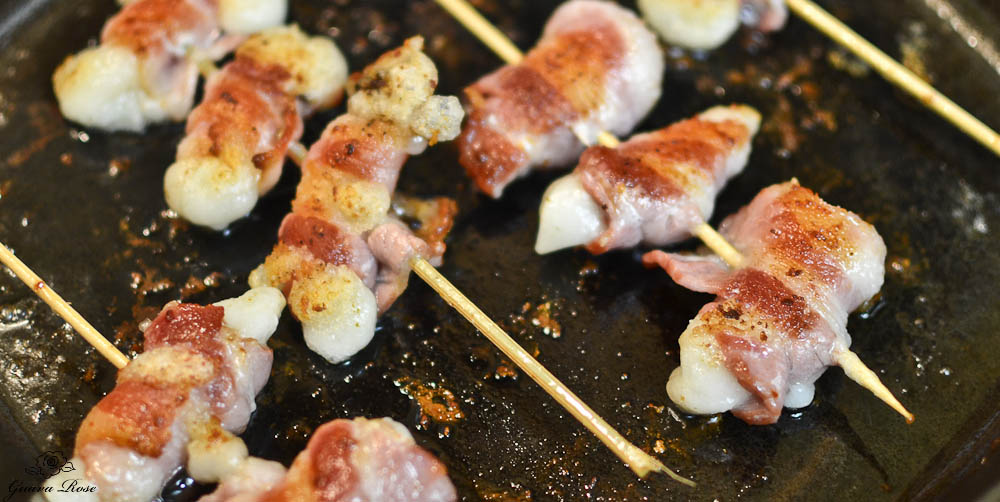 Bacon wrapped mochi in frying pan, close up